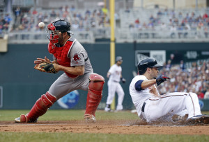 Minnesota's Brian Dozier slide past Red Sox catcher Blake Swihart during the Twins' 7-2 win Monday. The Associated Press