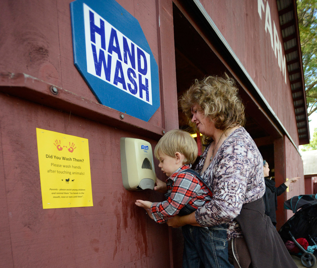 Two-year-old Tripp Proctor gets help from his grandmother Joann Harmon both of Bridgeton as they wash their hands after visiting Old McDonald's Farm petting zoo at the Fryeburg Fair.