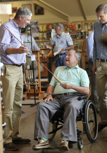 Former President George H.W. Bush looks over a fishing rod with Shawn Gorman, left, board chairman at L.L. Bean, during Bush's visit to the retail store in Freeport on Tuesday.