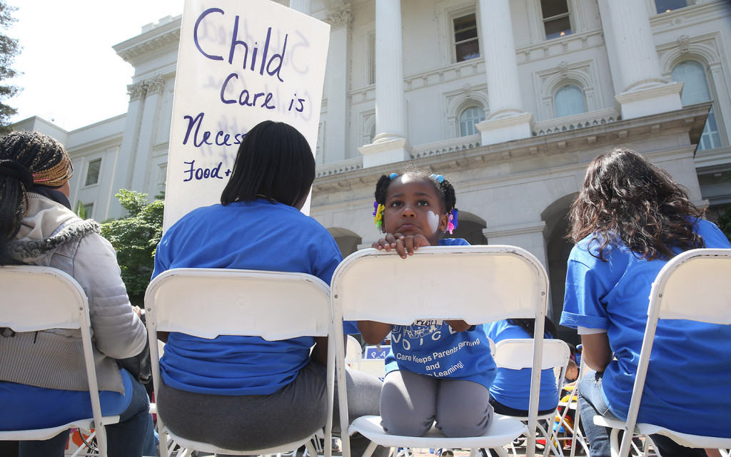 Saryah Mitchell sits with her mother, Teisa, Gay, left, a 2015 rally calling for increased child care subsidies at the Capitol in Sacramento, Calif. In much of the U.S., families spend more on child care for two kids than on housing. 