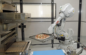 A robot places a pizza into an oven at Zume Pizza in Mountain View, Calif., recently. The startup, which began delivery in April, is one of a growing number of food-tech firms seeking to disrupt the restaurant industry. Marcio Jose Sanchez/Associated Press