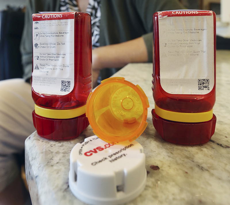 An open, amber-colored CVS pharmacy bottle lies between two of the innovative red ones that Target used before CVS took over operation of Target's drugstores earlier this year. Mel Evans/Associated Press