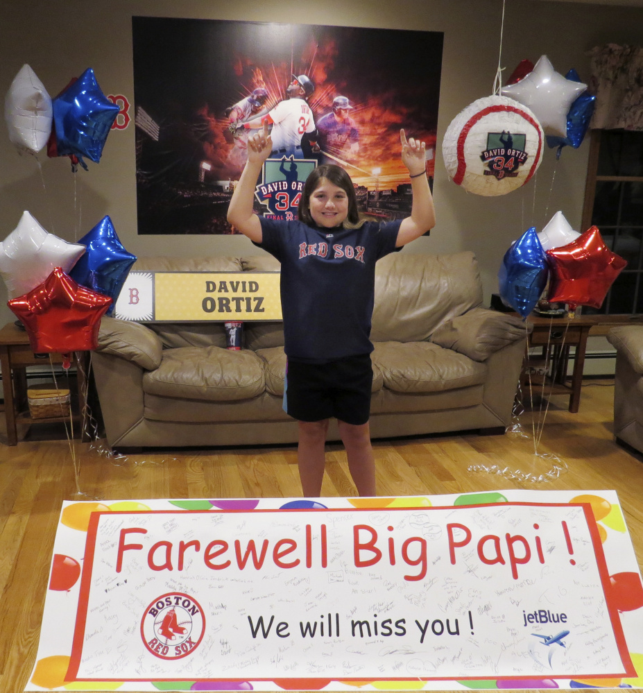 Caitlin Cunliffe points skyward, just like David Ortiz after a home run, as the 11-year-old from Minot poses with a farewell card put together with her father, Dan Cunliffe II, and signed by folks from all over Maine.