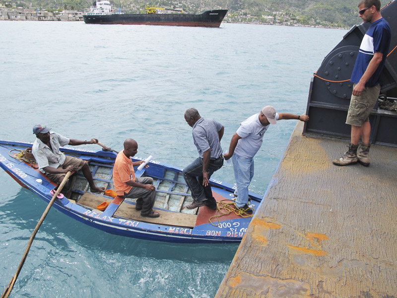 Sea Hunter volunteer Rick Woodbury of Scarborough, right, watches as Haitian officials depart the ship Friday morning. The deep-water dock in Miragoane is in sight, but is stillunattainable.