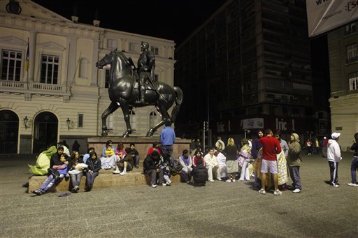 Residents sit in a main square in downtown Santiago early today after an 8.8-magnitude earthquake struck central Chile.