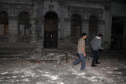 Residents walk by debris in Santiago, Chile's capital, after an earthquake struck. The quake hit 200 miles (325 kilometers) southwest of the capital, and the epicenter was just 70 miles (115 kilometers) from Concepcion, Chile's second-largest city,