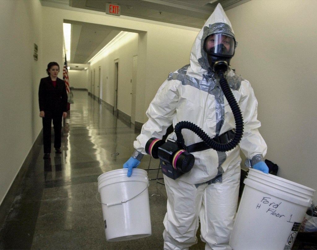 In this Nov. 6, 2001, AP file photo, biohazard worker Michelle Gillie, right, prepares to enter the office of Rep. Mike Pence, R-Ind., in the Longworth House office building on Capitol Hill in Washington. At left is Michelle Richman, scheduler for Rep. Grace Napolitano, D-Calif.