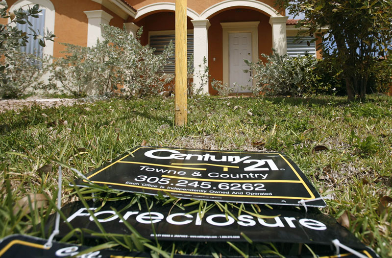 A sign lies on the ground in front of a foreclosed home in Homestead, Fla. The number of borrowers falling behind on their mortgage payments dropped sharply at the end of 2009, a sign the foreclosure crisis is beginning to ebb.