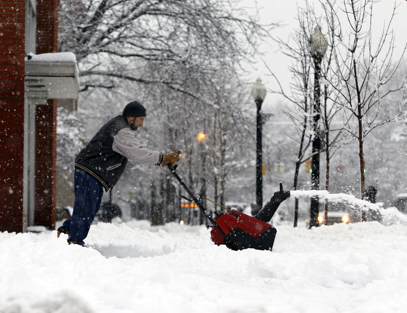 Jacob Faqiry clears snow in front of a business in Albany, N.Y., on Wednesday, Feb. 24, 2010. The first in a double-whammy storm has dumped more than a foot of wet, heavy snow on parts of eastern New York, closing hundreds of schools and knocking out power to more than 100,000 customers. (AP Photo/Mike Groll)