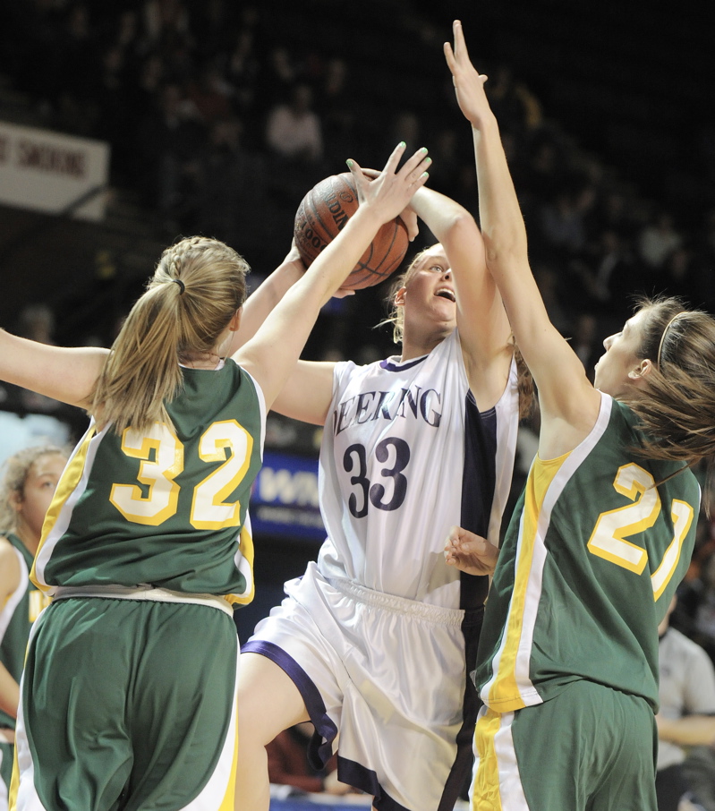 Kayla Burchill, who scored 19 points for Deering, looks to drive against Chantalle Desjardins, left, and Alexa Coulombe of McAuley during their Western Class A semifinal. Deering won, 45-35.
