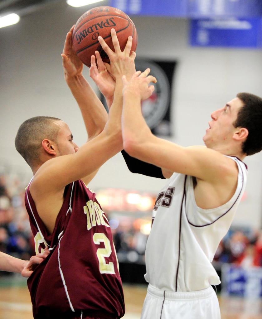 Tyler Tholl of Thornton Academy, left, and Adam Szklany of Windham compete for a rebound Friday night during their Western Class A quarterfinal at the Portland Expo. Windham earned a 59-42 victory.