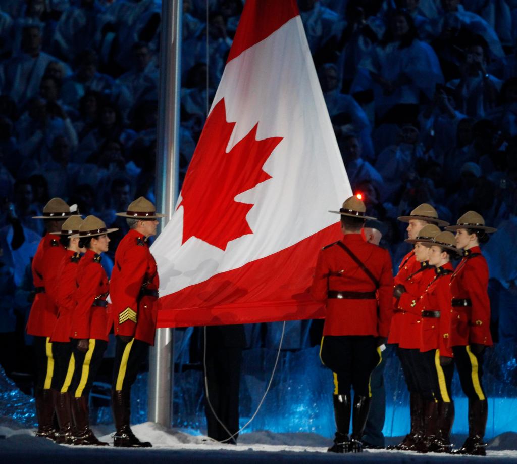 The Canadian flag is raised by members of the Royal Canadian Mounted Police during opening ceremonies for the Winter Olympics on Friday.