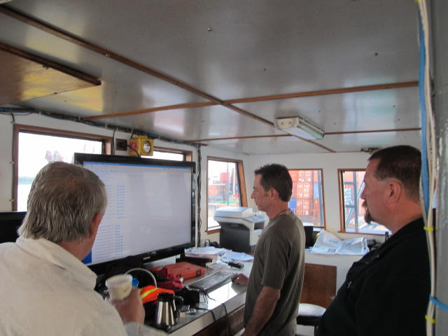 Sea Hunter owner Greg Brooks, left, checks the long-range weather forecast between Miami and Haiti on Monday along with ship captain Gary Esper, center.