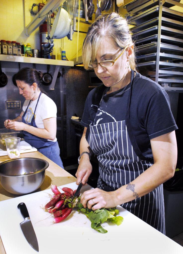 Krista Kern Desjarlais, chef and owner of Bresca in Portland, prepares French breakfast radishes Thursday for a starter served with olive oil and goat butter. At left is sous chef Courtney Loreg. Inset photo shows shrimp on the barby at Hugo's.