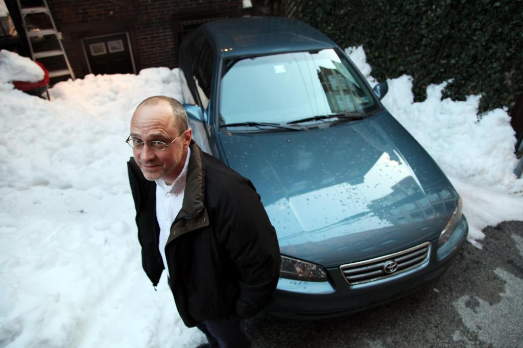 John Caskey stands with his 2001 Toyota Camry in Philadelphia. Caskey is an economics professor at Swarthmore who recently bought the Camry and sees absolutely zero sense in buying a new car.
