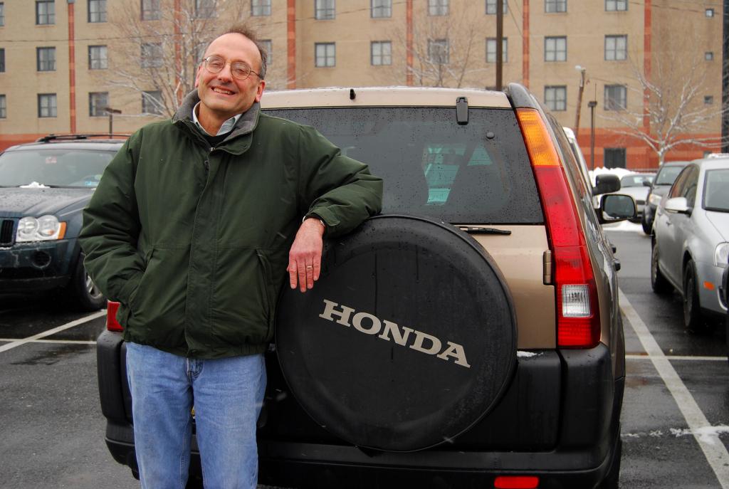 Bill Stull leans against his Honda CR-V at Temple University in Philadelphia, where he is the chairman of the economics department. “A car is a presentation of self,” Stull said. “I am sort of a practical person who ís not particularly interested in showing anything other than practicality in the kind of car I buy.”