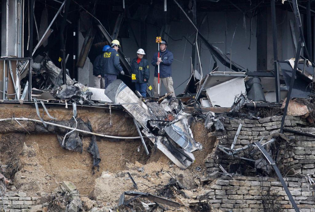 Federal investigators search through the aircraft wreckage inside a building in Austin, Texas, on Friday. Officials said that Joseph Stack flew his plane into the building Thursday, where IRS employees worked, killing himself and one person inside.