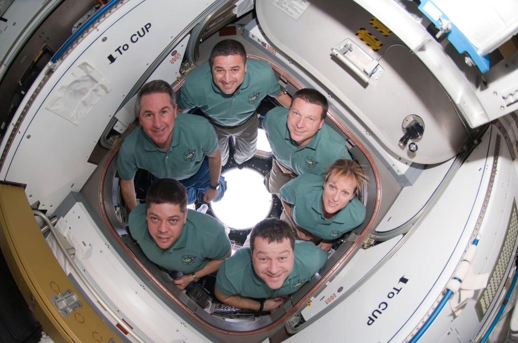 Endeavor crew members pose in the newly installed cupola of the space station. Pictured clockwise from the top are: NASA astronauts George Zamka, commander; Terry Virts, pilot; and Kathryn Hire, Nicholas Patrick, Robert Behnken and Stephen Robinson, mission specialists.