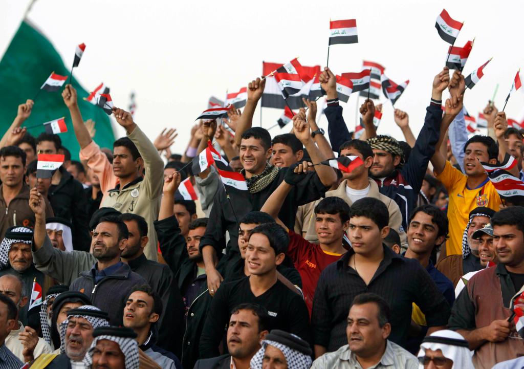 Men wave the Iraqi flag at a campaign rally attended by Prime Minister Nouri al-Maliki in Basra, Iraq, on Saturday.