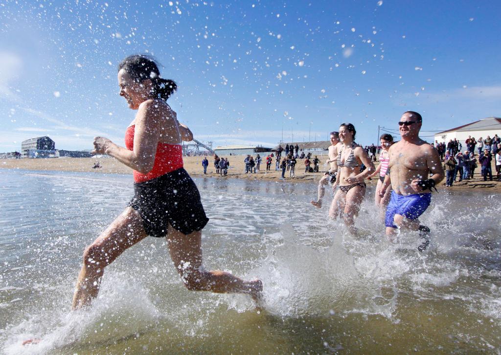 Alison McCormick of Old Orchard Beach leads a group into the Atlantic during the carnival's Penguin Plunge.