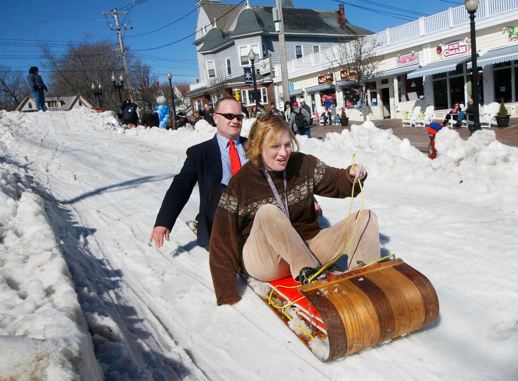 Clarence Stewart of Old Orchard Beach and Trish Perlman of Ashfield, Mass., race down Old Orchard Street on a toboggan during the festivities Saturday.