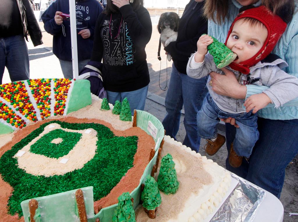 Talan LaChance, 1, of Old Orchard Beach tastes a cake depicting the town’s Ballpark made by his grandmother, Jan Tabone. Pieces of the cake brought donations for restoring the facility.