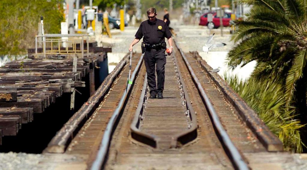 Mike Foremny, a Special Agent with the Railroad police, works the scene where three girls were struck and killed by a south bound train on the crane creek Railroad bridge in Melbourne, Fla., Sunday, Feb. 21, 2010. (AP Photo/Florida Today, Craig Rubadoux)
