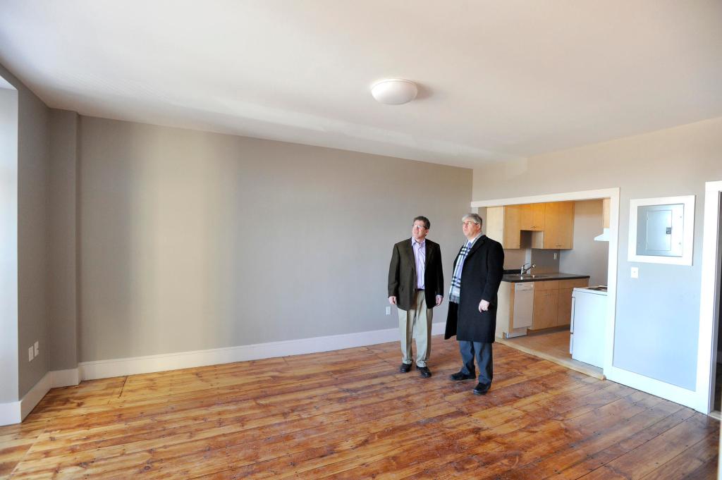 Developer Greg Shinberg, left, shows Portland Mayor Nick Mavodones a new apartment in the renovated former dormitory.