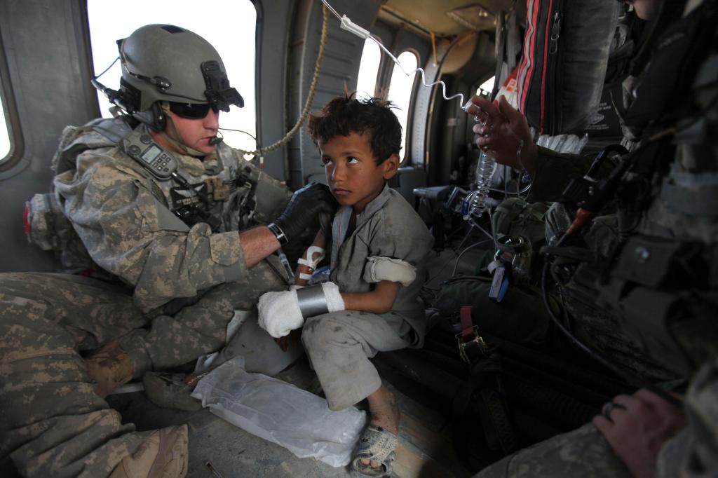 Airborne over Marjah, U.S. Army flight medic Sgt. Bryan Eickelberg of Arden Hills, Minn., tends to an Afghan boy wounded earlier by an improvised explosive device, according to troops on the ground on Tuesday in Afghanistan.