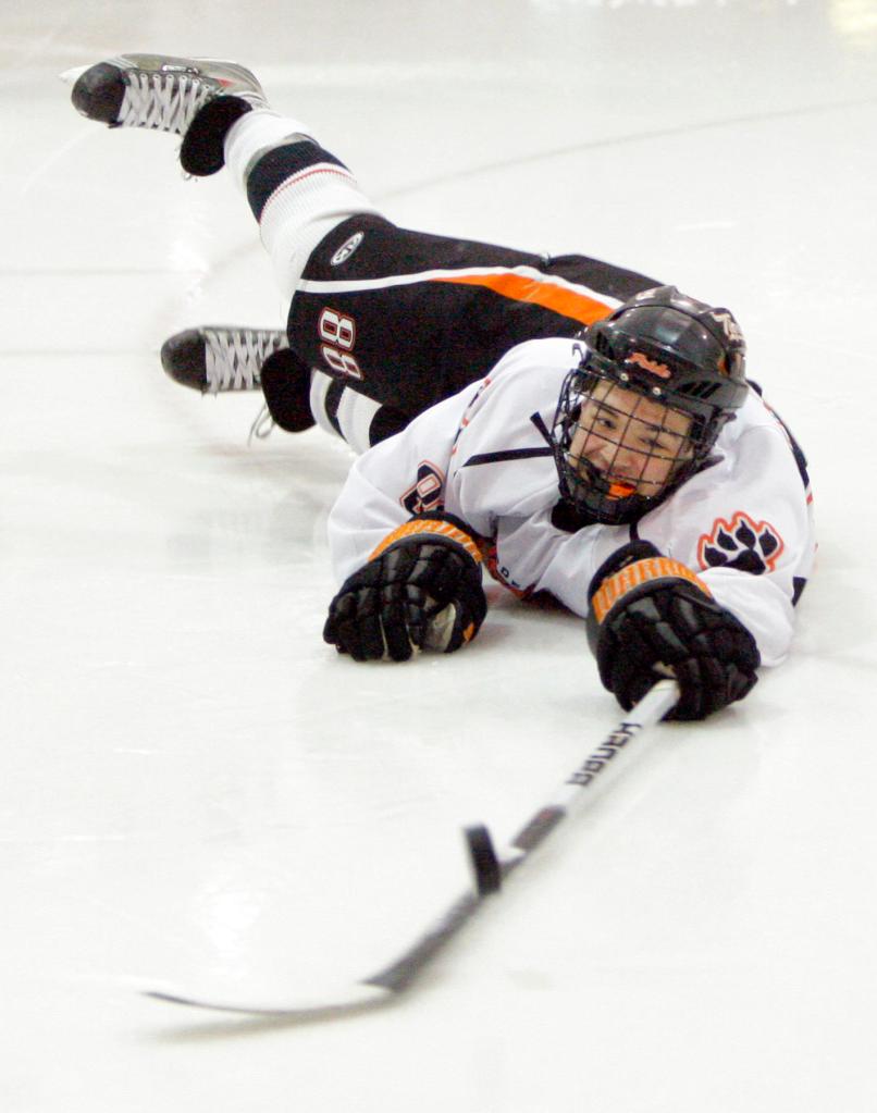 Gregory Rec/Staff Photographer: Biddeford forward Derek Reny makes a diving lunge after the puck in a vain attempt at a shot on goal during the quarterfinal game against Scarborough at Biddeford Ice Arena on Tuesday, February 23, 2010.