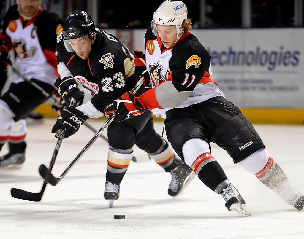 Tyler Ennis, right, of the Portland Pirates attempts to control the puck against Chris Connor of the Wilkes-Barre/Scranton Penguins in Portland’s 2-1 win. The Pirates are tied for first.