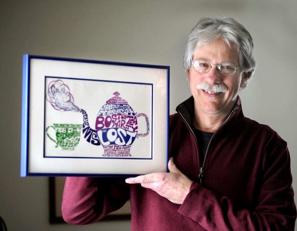 David Kinsman poses with a piece from his collection of vintage rock posters, this one from the ’60s-era nightclub the Boston Tea Party.