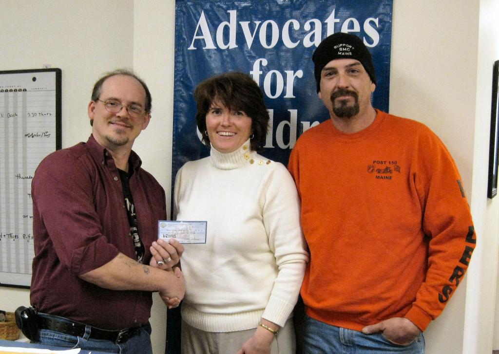 Larry Buteau, left, and Adam Carlton present Betsy Norcross Plourde of Advocates for Children with funds raised at a food festival.