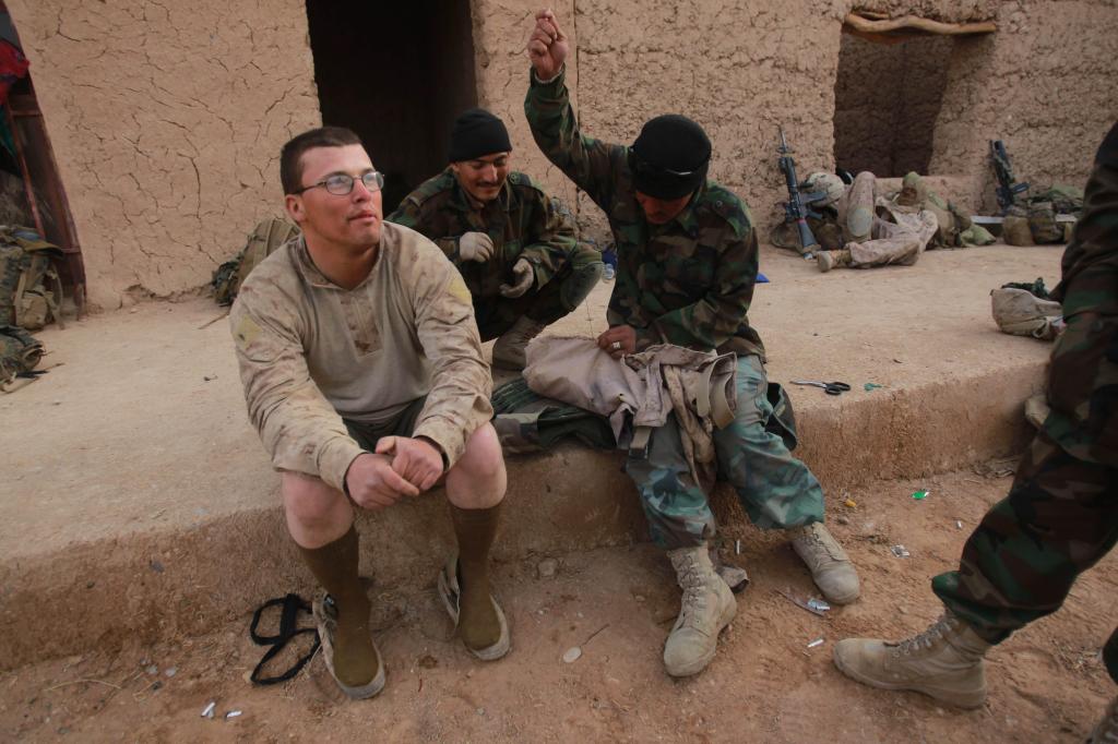 Marine Lance Cpl. William Smith has his torn pants mended by an Afghan National Army soldier in Marjah, Afghanistan, on Saturday.