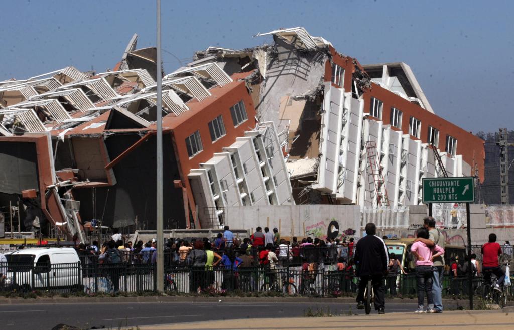 Residents look at a collapsed building in Concepcion, Chile, on Saturday after a magnitude-8.8 earthquake struck central Chile. The epicenter was 70 miles from Concepcion, Chile’s second-largest city. The nation was rocked by more than 50 aftershocks topping magnitude-5, including one of magnitude-6.9.