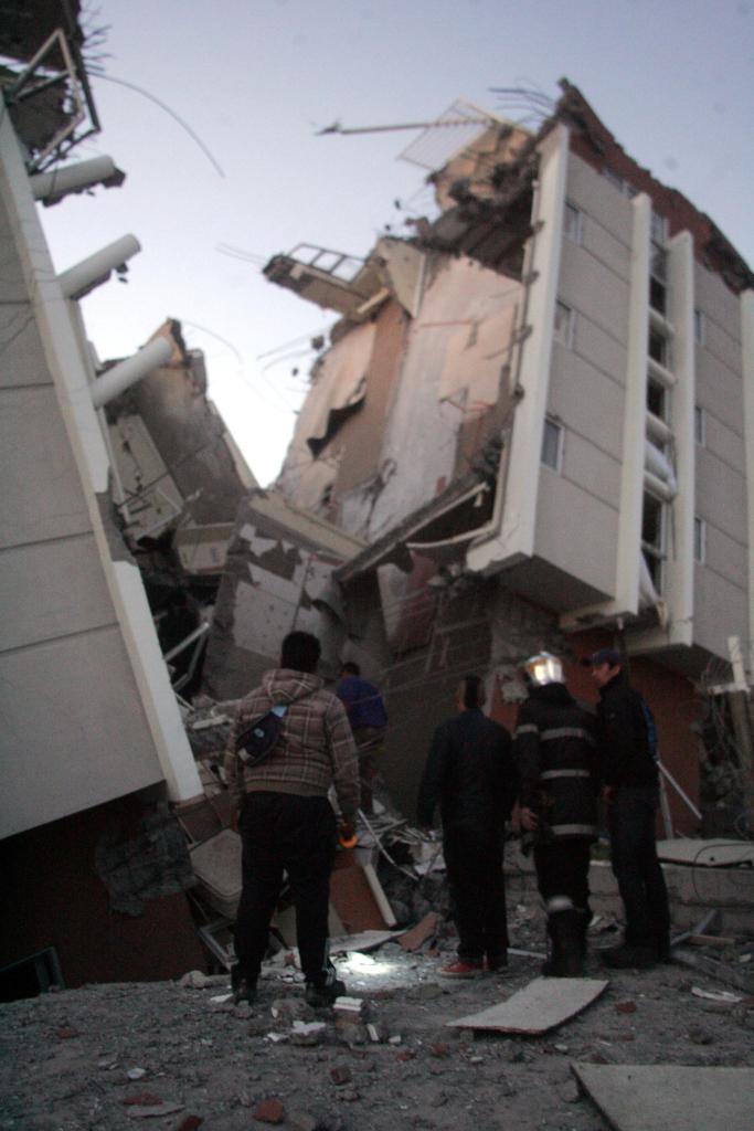 Residents look at a collapsed building in Concepcion, Chile, on Saturday after a magnitude 8.8 quake struck. The epicenter of the quake was 70 miles from Chile’s second-largest city.