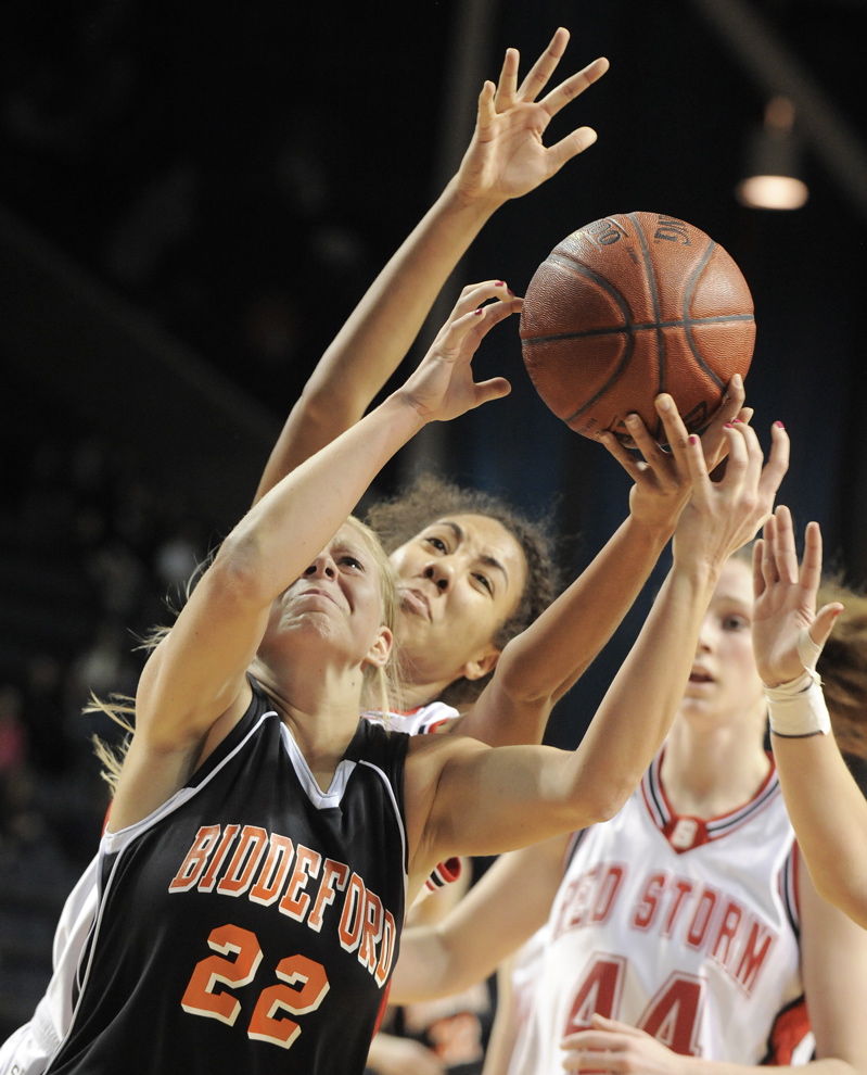 Amethyst Hersom of Biddeford reaches for a rebound ahead of Carly Rogers of Scarborough during their Western Class A semifinal at the Cumberland County Civic Center. Scarborough will meet Deering in the final.