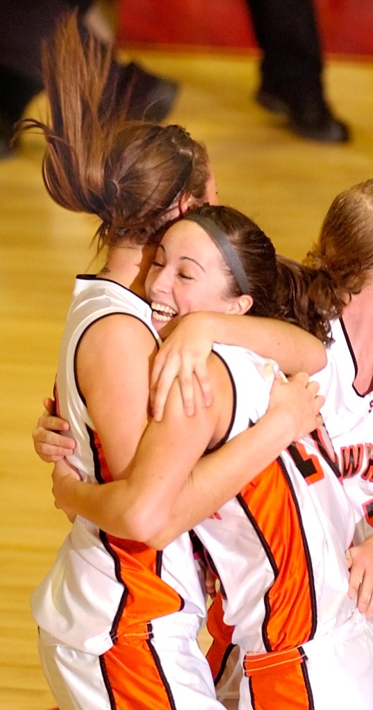 Liz Noddin, right, hugs teammate Mackenzie Smith after scoring the winning basket to send Skowhegan to the Class A state championship game.