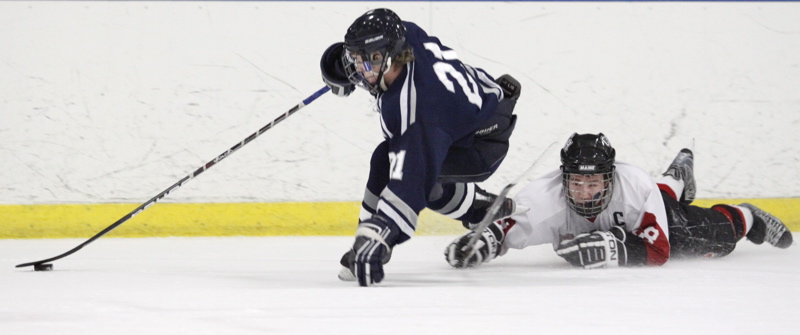Yarmouth’s Alex Kurtz maintains control of the puck as he gets past Wayne Neiman of Camden Hills.