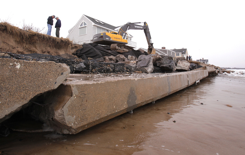 Employees of Foglio, Inc., work to shore up the remaining shoreline that was eroded by waves from the afternoon high tide Thursday along Wells Beach. About 150 feet of seawall fell over during high tide Thursday morning. The wall protected the houses at 287 and 293 Island Beach Road.