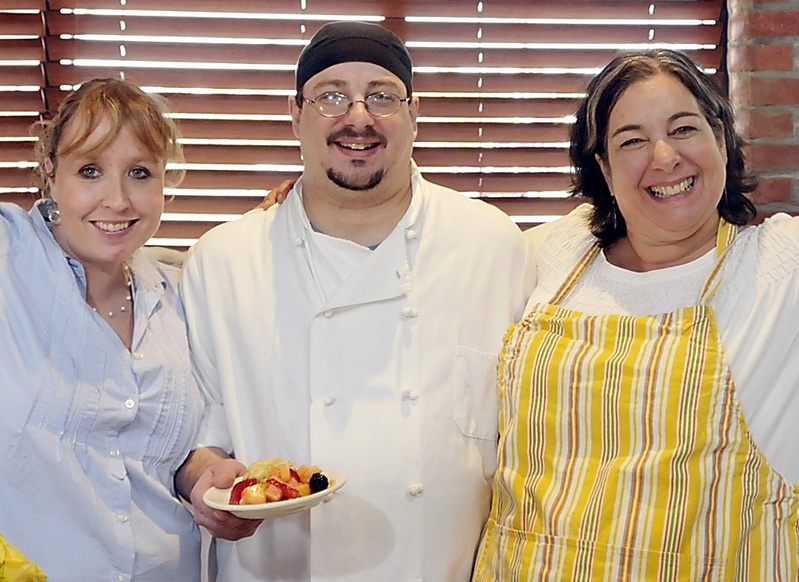 Kaylin Weeks, George Rall and Lisa Kostopoulos of the Good Table cheer thecook-off results. The event raised funds for Preble Street.