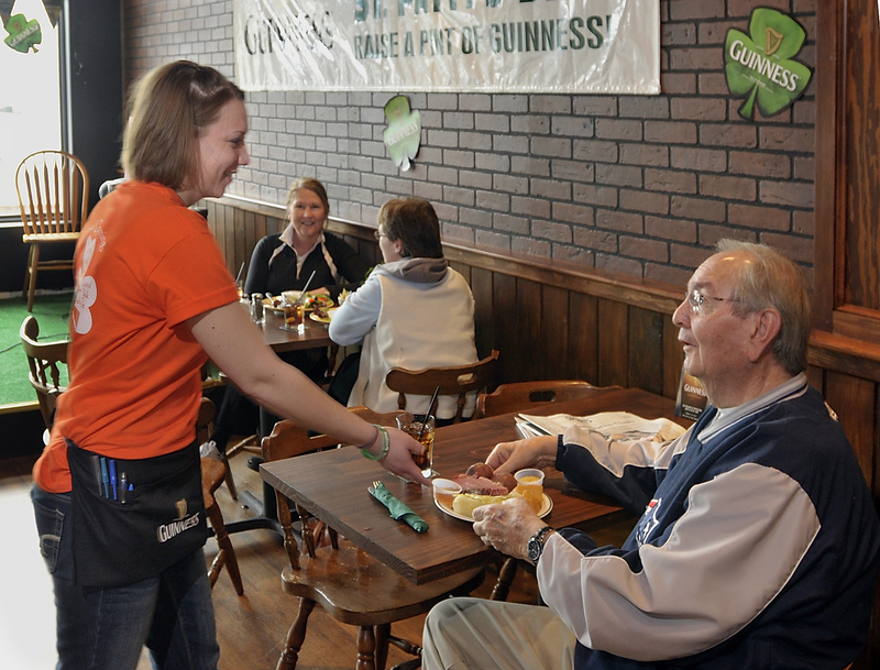 Waitress Kayla Rydzewski serves customer Mike Salter of Brunswick at Byrnes Irish Pub, one of the new businesses in the recently developed Maine Street Station.