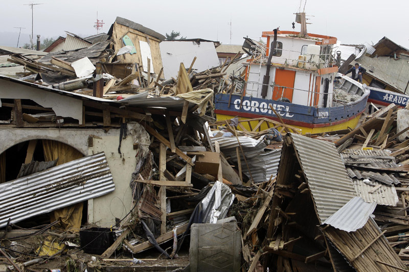 A boat lies marooned on top of a destroyed house in Dichato, Chile, today.