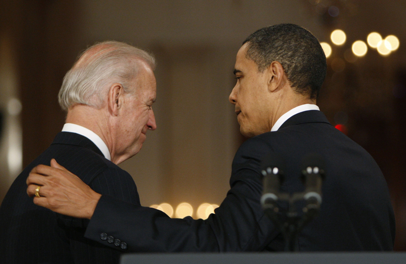 President Barack Obama, right, puts his arm on Vice President Joe Biden as they walk out together after making a statement to the nation Sunday night following the final vote in the House of Representatives for comprehensive health care legislation.