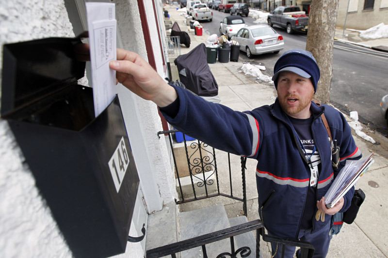 Letter carrier Kevin Pownall delivers mail in Philadelphia today. The U.S. Postal Service is increasing the pressure for dropping Saturday home delivery as it seeks to fend off massive financial losses.