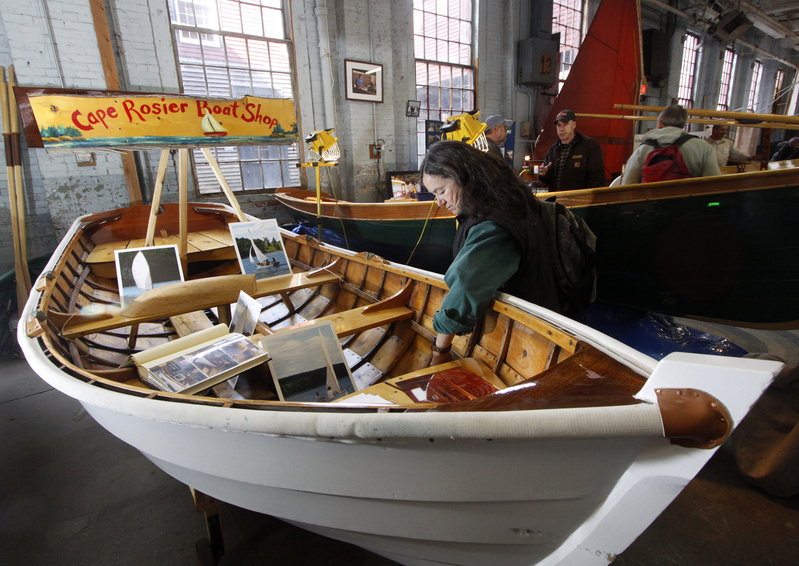 Suzanne Phillips of Cape Cod looks over a rowing and sailing dinghy made by Peter Chase of Cape Rosier Boat Shop in Harborside at the annual Maine Boatbuilders Show.