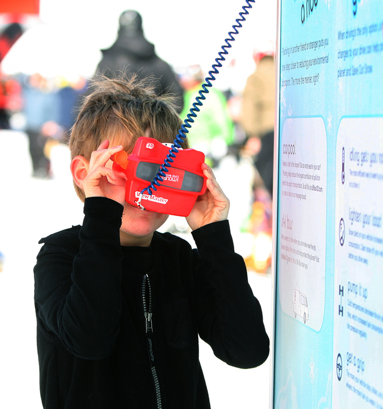 Alexander Baribeau, 7, of Bethel looks through a View-Master at a ski bus that runs on recycled vegetable oil at the Clif Bar tent. The display was part of Clif Bar’s Save Our Snow campaign to raise awareness of the effects of climate change. Alexander was at Sunday River to take a ski lesson with the Gould Academic Competition Program.