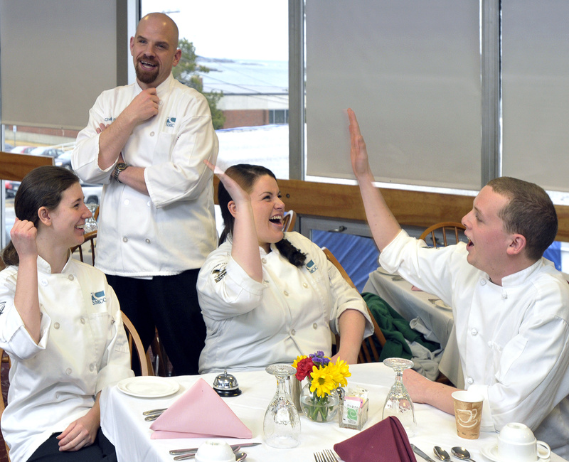 Chef Tony Poulin, an SMCC culinary arts instructor, looks on approvingly as students Cassette, Bradeen and Ault celebrate a mock-competition victory while practicing for the main event, which begins Saturday.