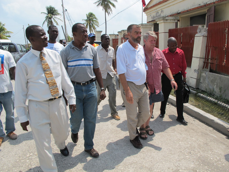 Lewiston native Fr. Marc Boisvert, center, and Sea Hunter owner Greg Brooks of Gorham walk from one meeting with government officials to another today in Les Cayes, Haiti.
