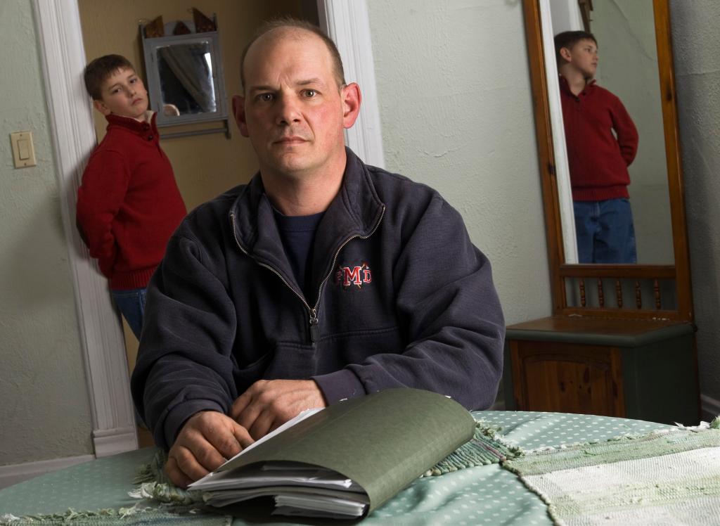 Terry Becker – with his son Nate in their Milton, Wis., home – says medical debt for the boy has left him with bad credit. He says he was rejected for eight jobs after authorizing credit checks.
